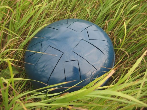 Steel tongue drum laying on the grass