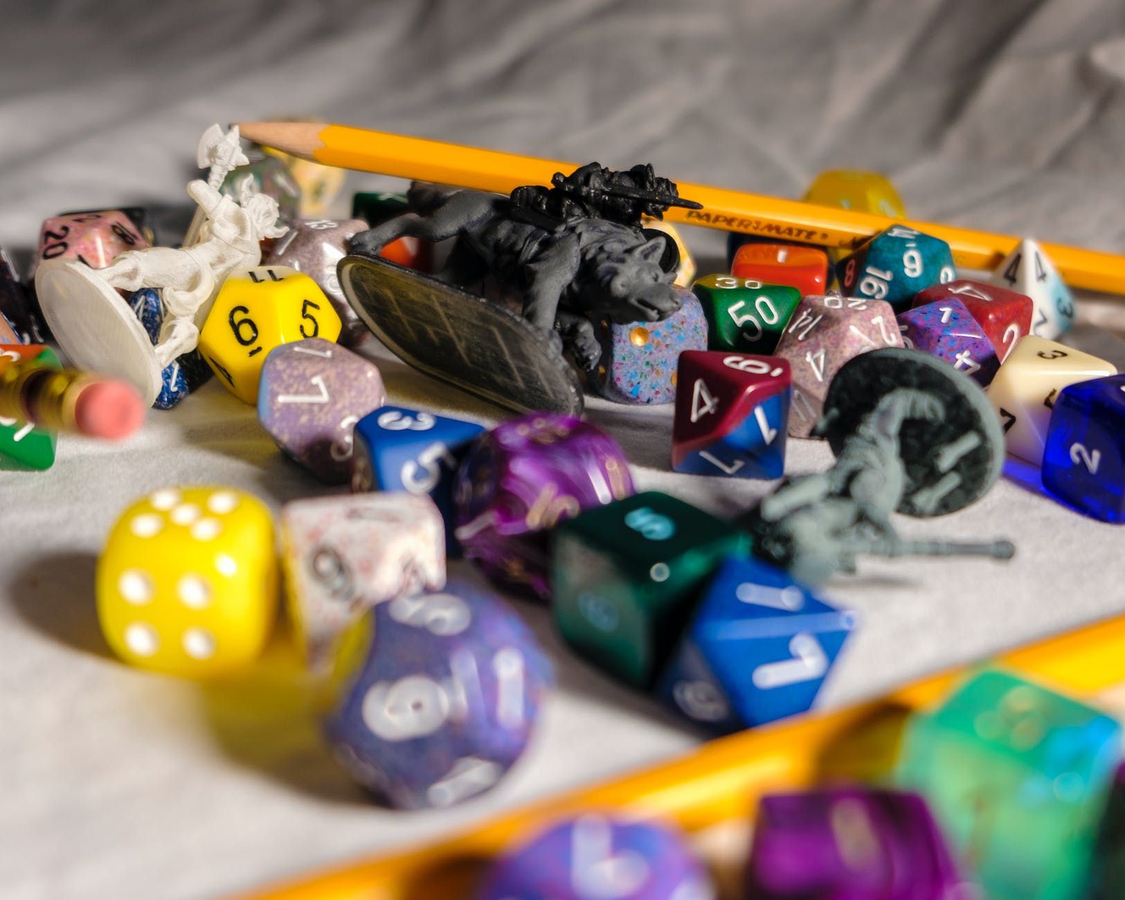 set of colorful dices on desk with pencils and toys