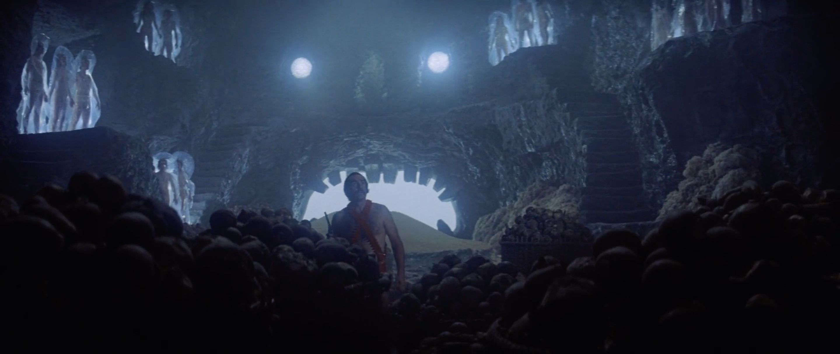 Inside the floating stone head. Why is Zardoz flying around with a bunch of inanimate naked people? No idea. Go ask him.