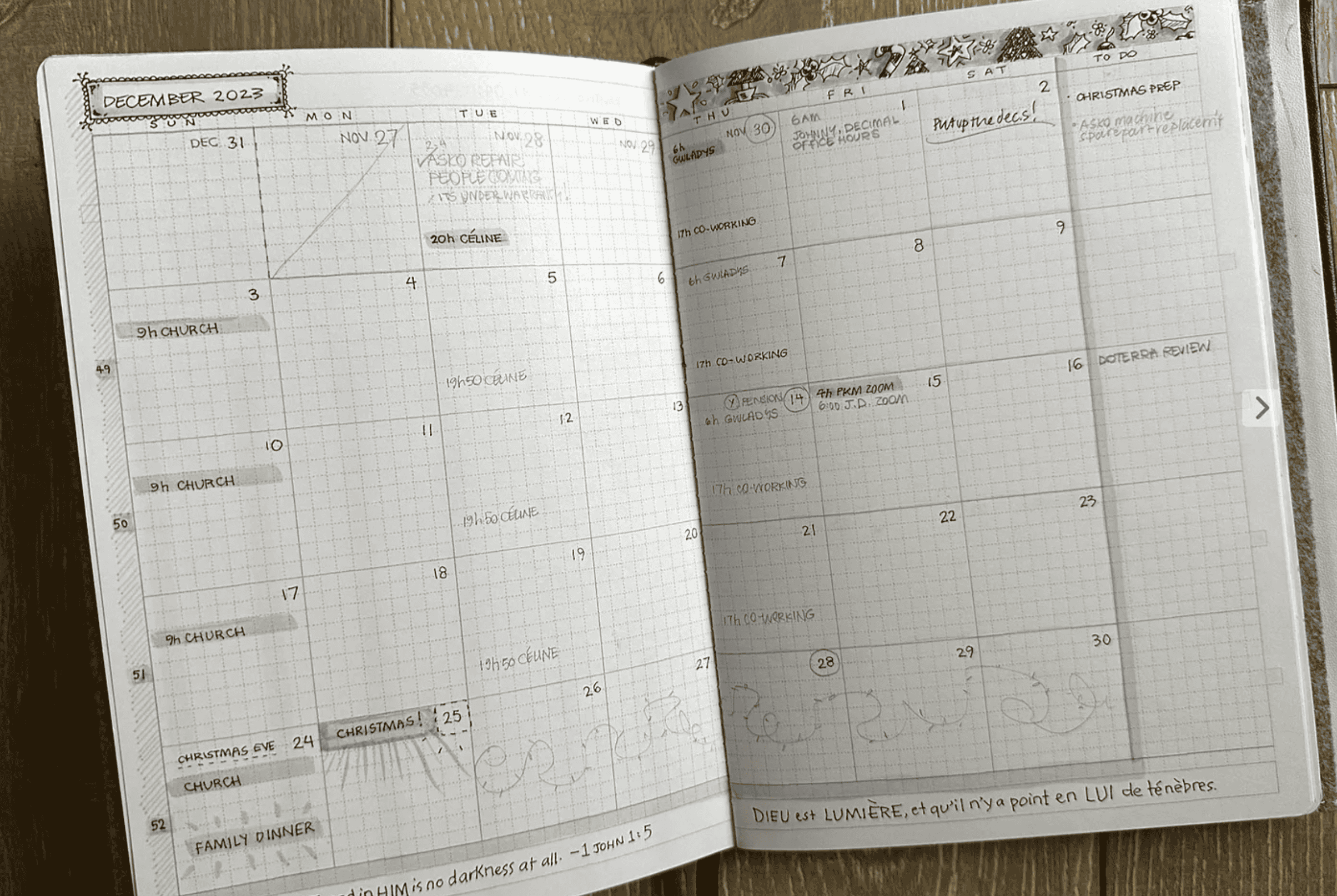 An open spread showing one month on grid paper. Numbers are drawn by hand, and there are monochrome hand drawn christmas decorations on the top right page