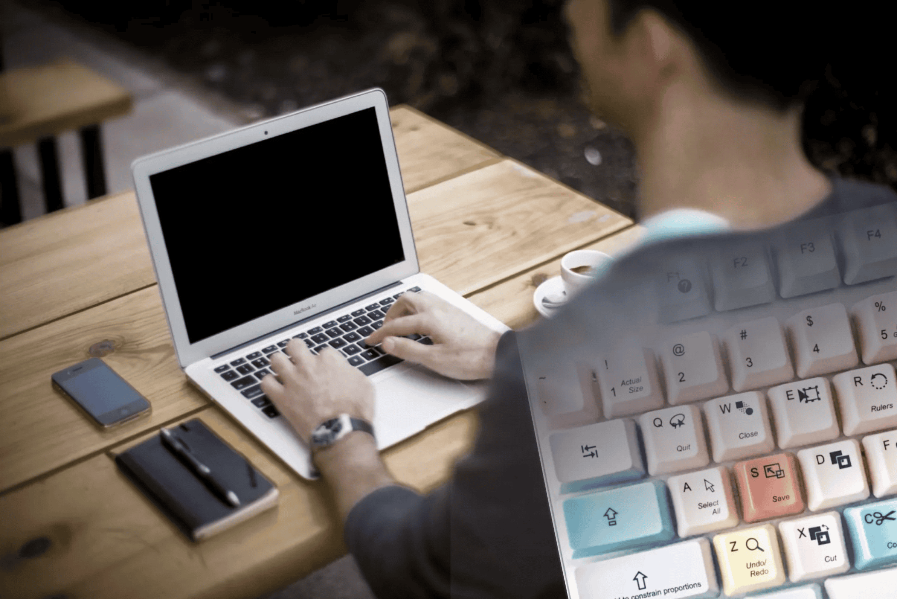 Seen from a back/side angle and coming out of the right side of the frame, a man sits at a desk typing on a laptop. There’s an overlay of a computer keyboard faded into his back and left shoulder. Image compiled by Author from Photo by https://unsplash.com/@alejandroescamilla on https://unsplash.com, and Photo by https://unsplash.com/@girlwithredhat on https://unsplash.com