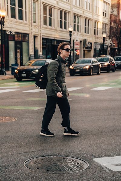 A young man crossing a busy intersection in a big city