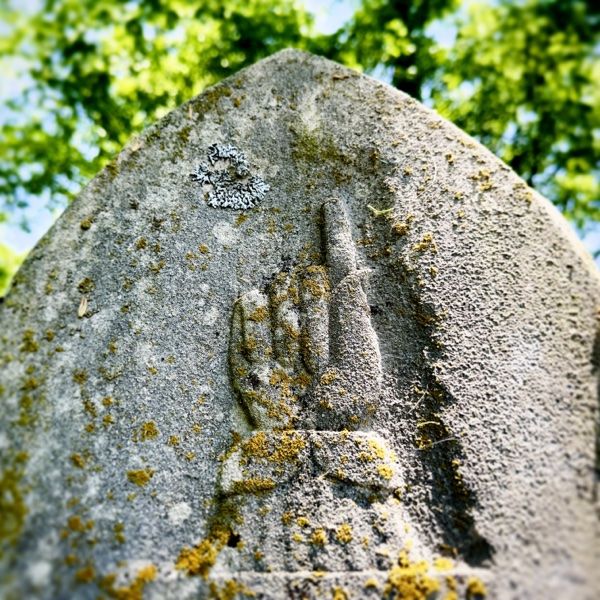 Photo of finger on tombstone pointing heavenward