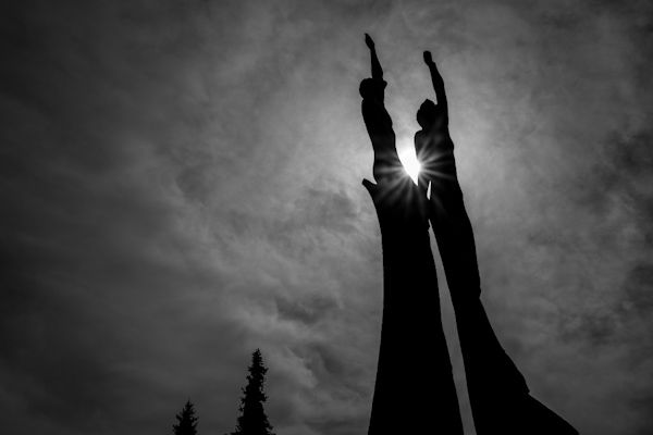 Image of Robert Koepnick statue in silhouette with sun visible