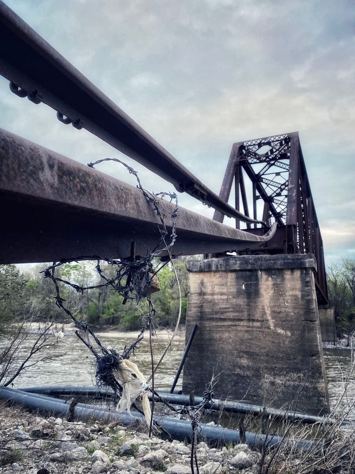 aftermath of an angry pearl river in mississippi — twisted railroad tracks and torn barbed wire.