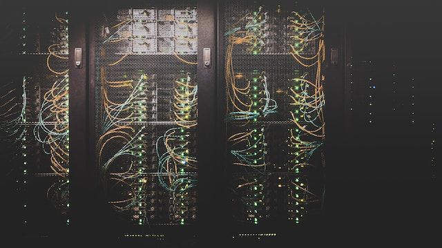A computer server cabinet in the dark. Photo by Taylor Vick on Unsplash