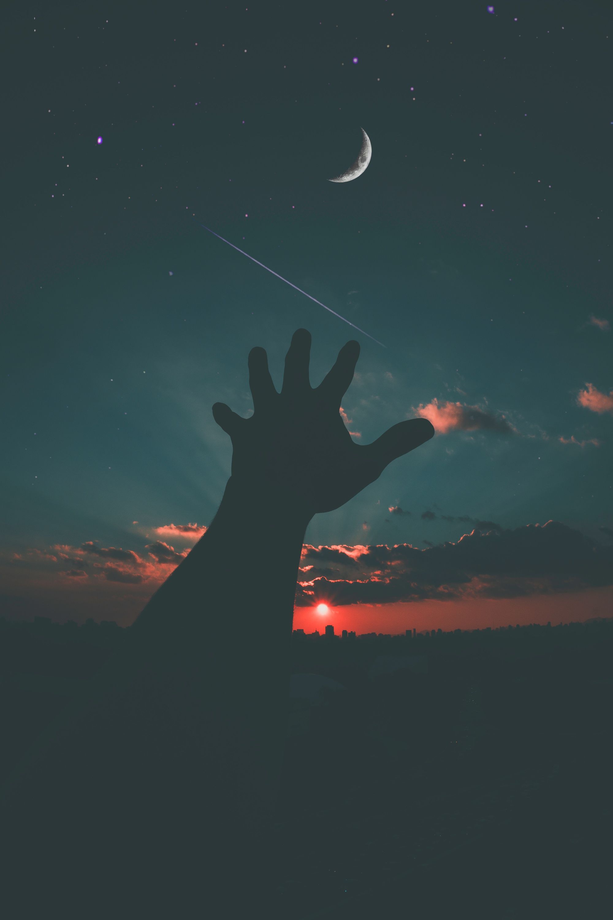 Photo of a man stretching out his hand toward the night sky