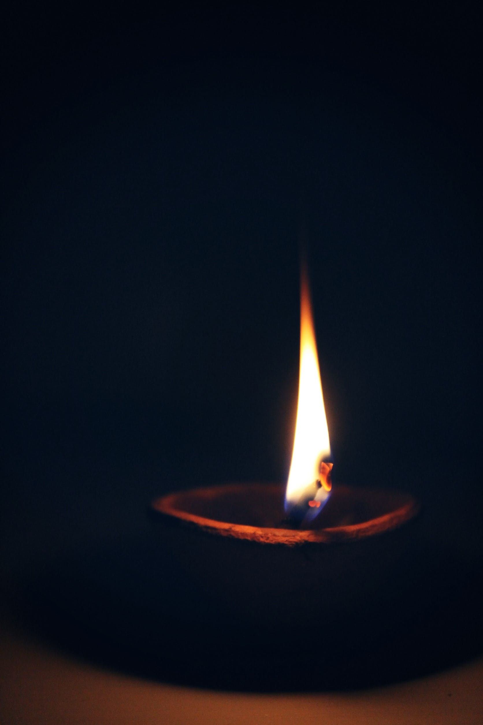 Photo of a candle burning in the dark