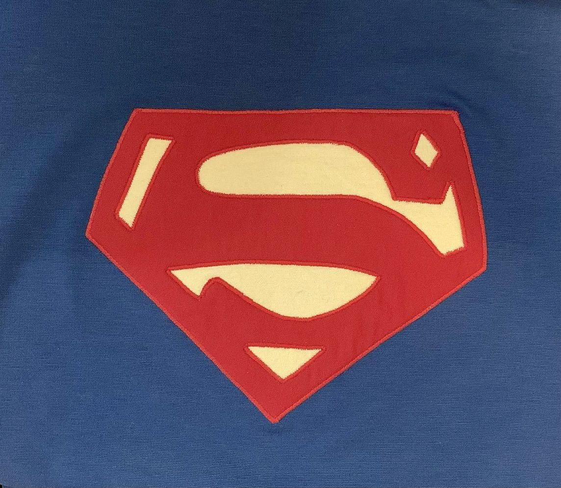 a close up of the color years Superman shield from Adventures of Superman