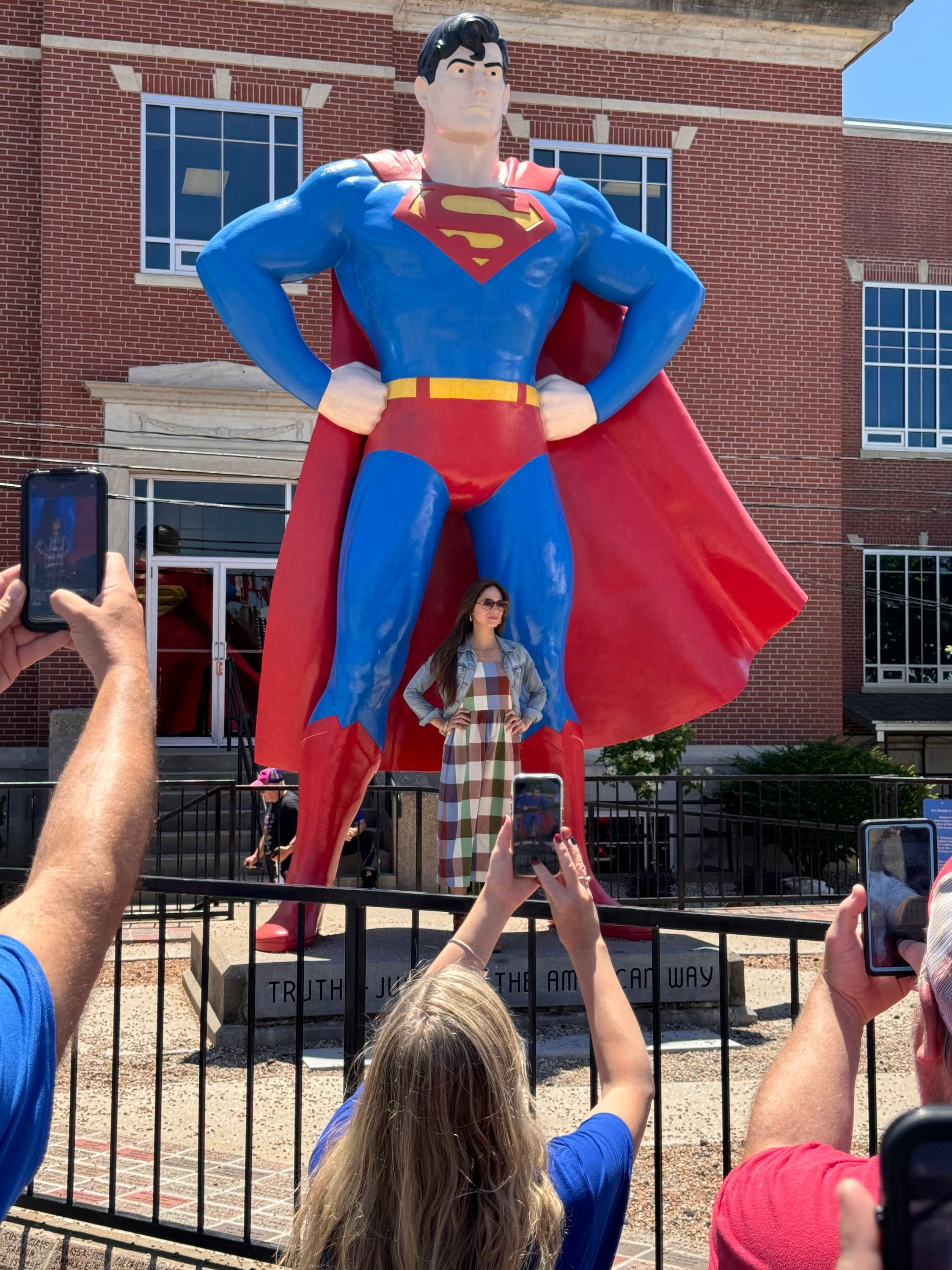 Kristen Kreuk standing in front of the giant Superman status in Metropolis