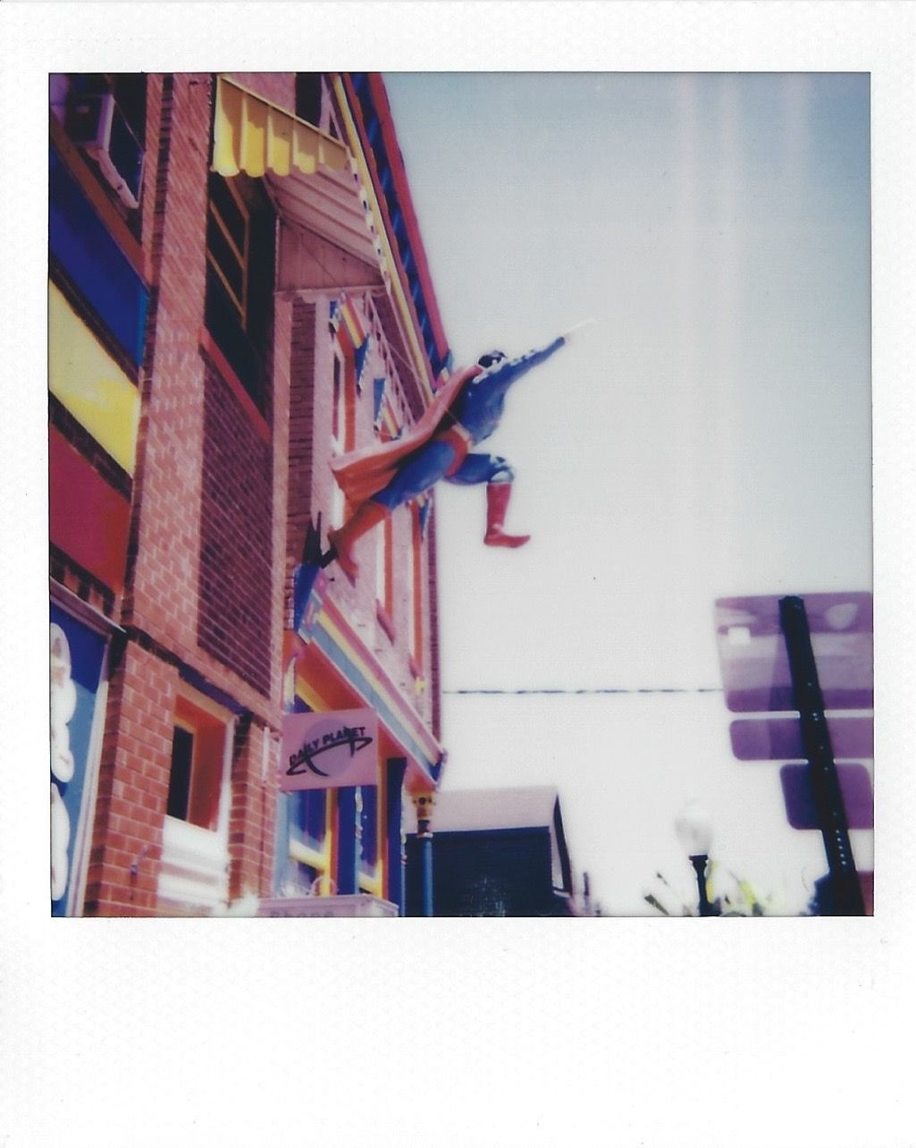 A polaroid photo of the Superman status leaping off the side of the Super Museum
