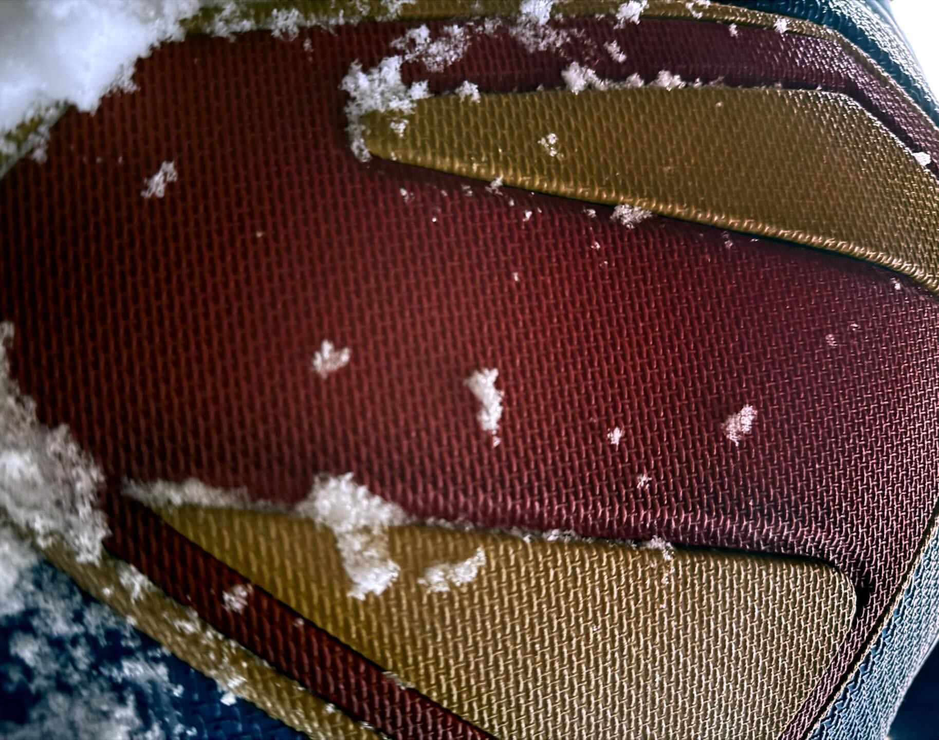 A close up of the new Superman shield covered in snow