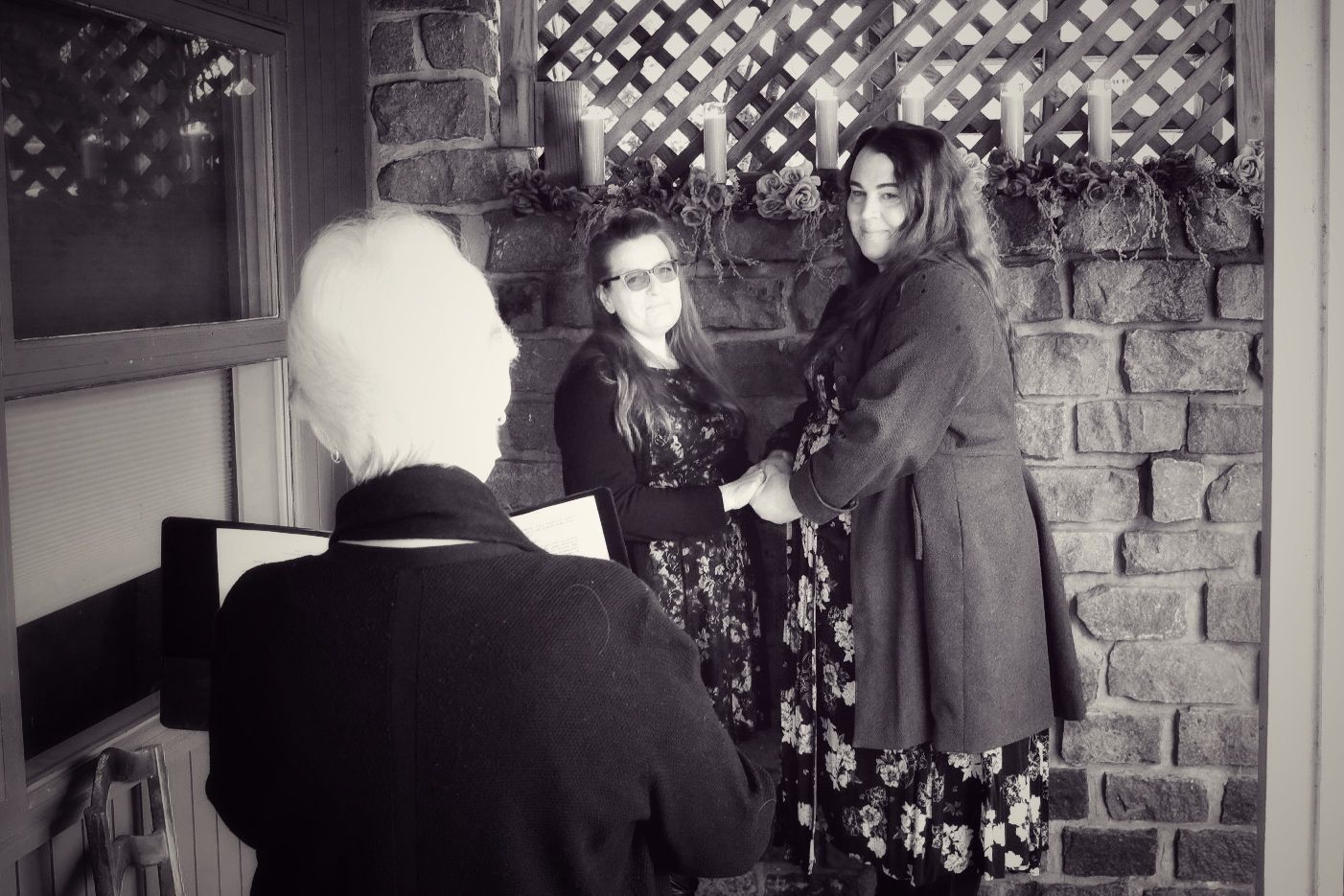 Holly and Jina holding hands and looking at the officiant.