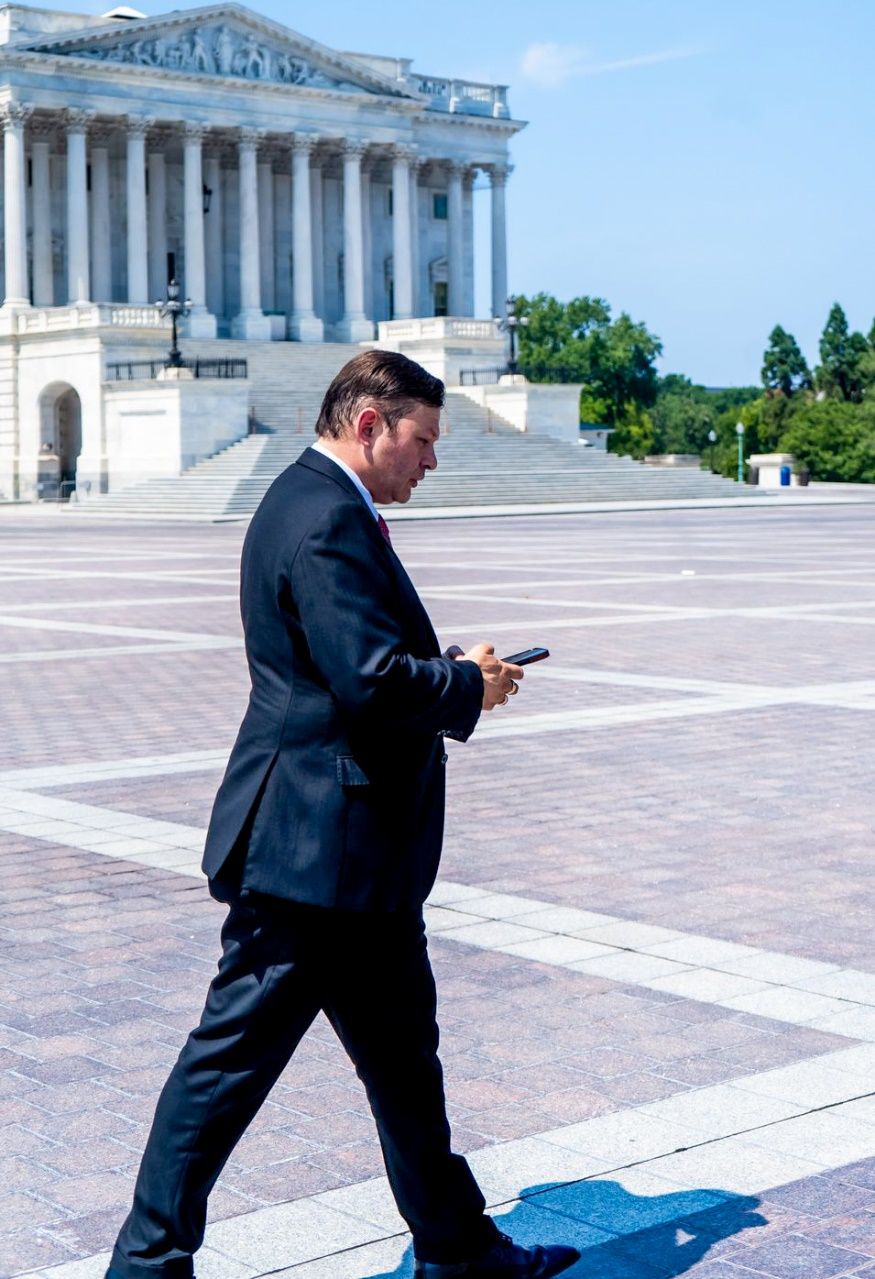 A person walking in front of a building Description automatically generated