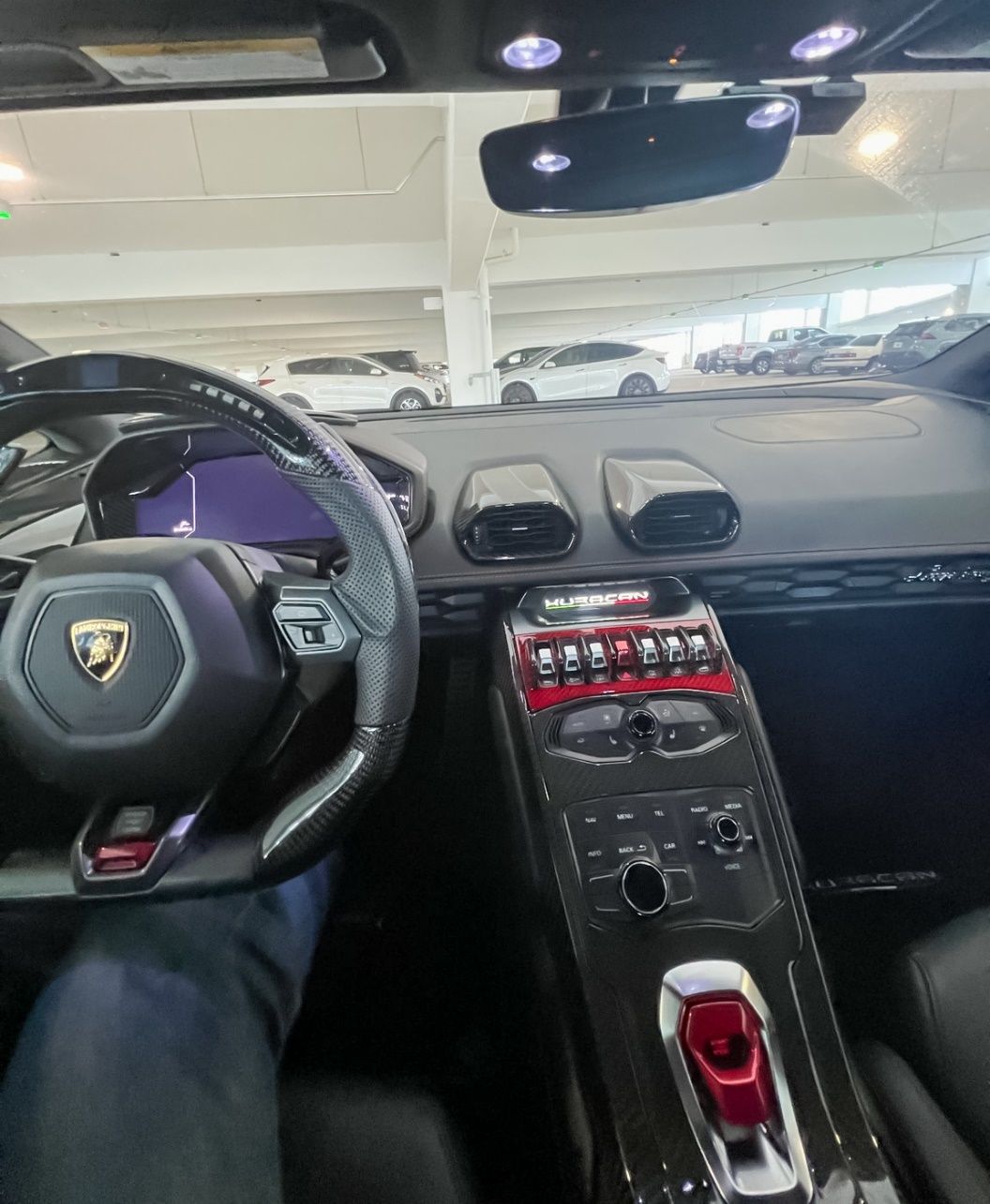 Inside a car with a steering wheel and dashboard Description automatically generated