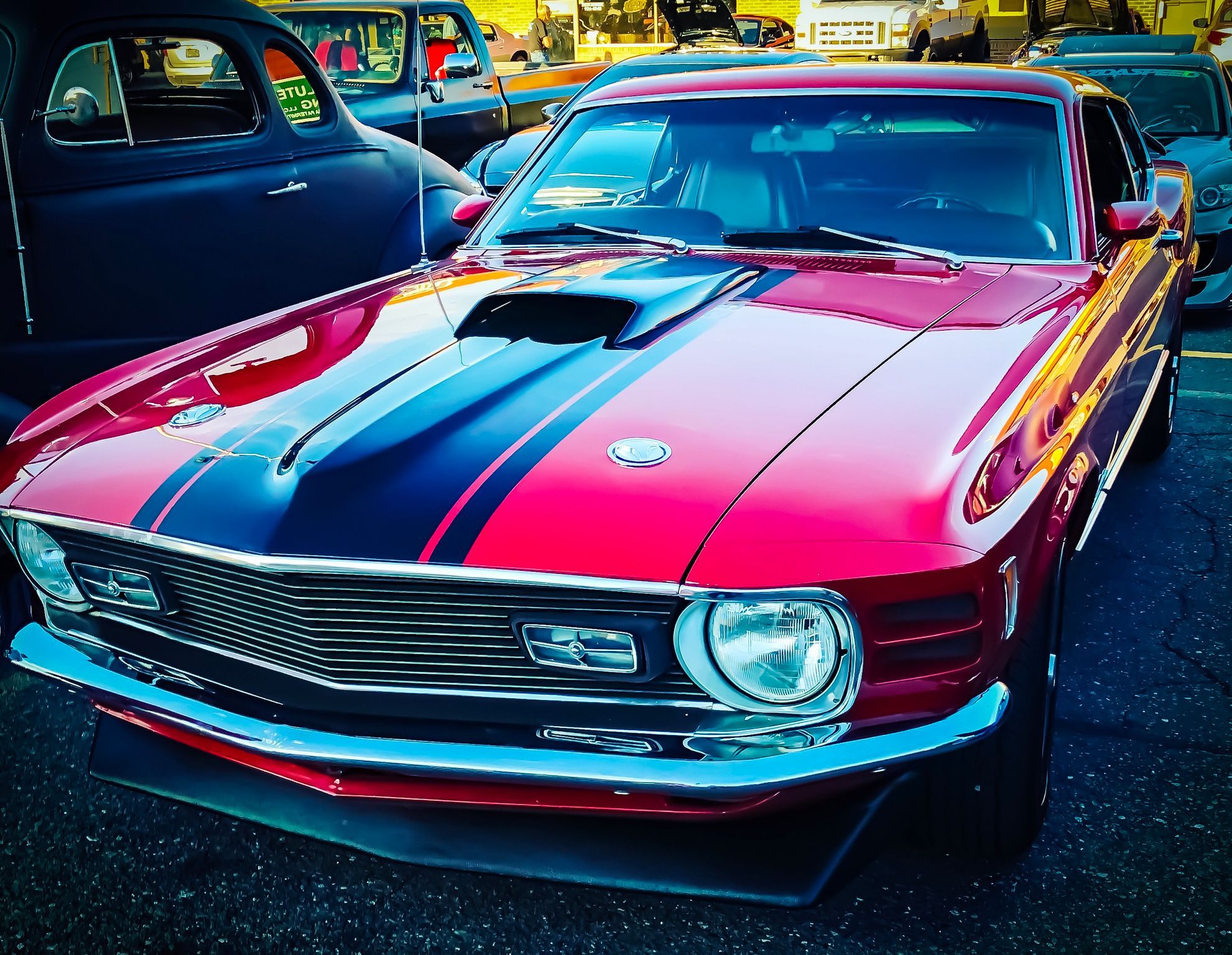 A red and black car parked in a parking lot Description automatically generated