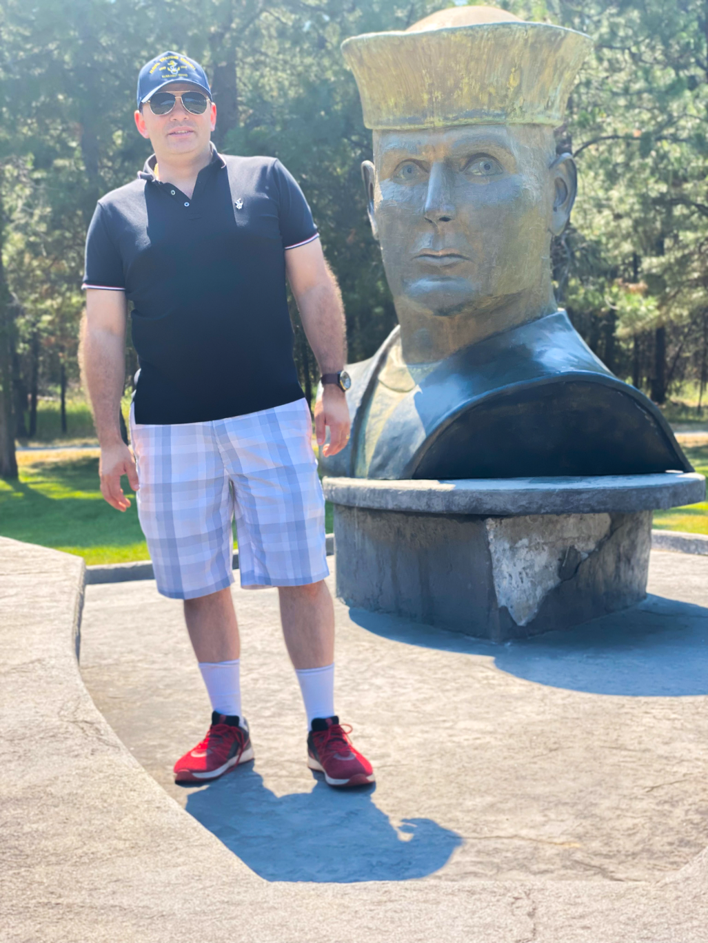 A person standing in front of a statue Description automatically generated