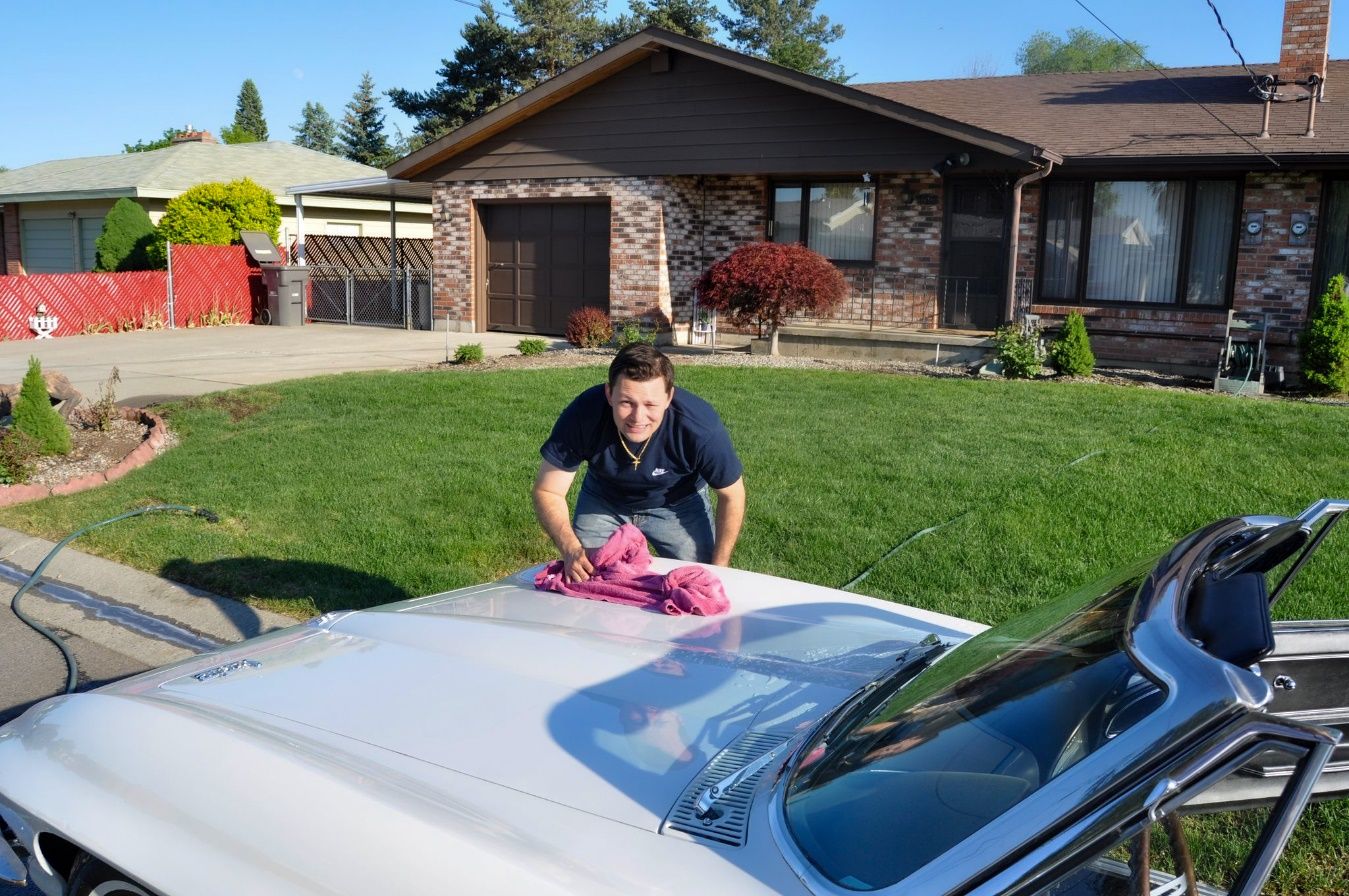 A person cleaning a car Description automatically generated