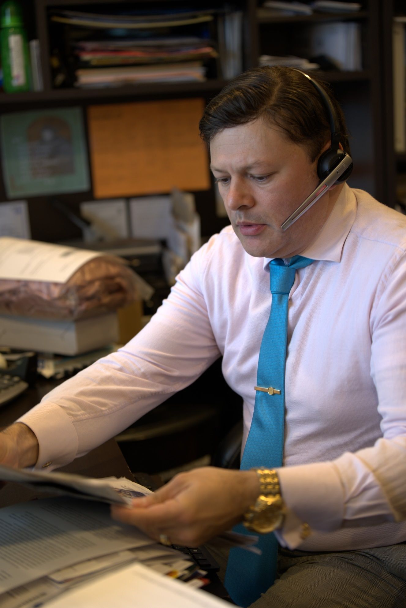 A person wearing a headset and a blue tie Description automatically generated