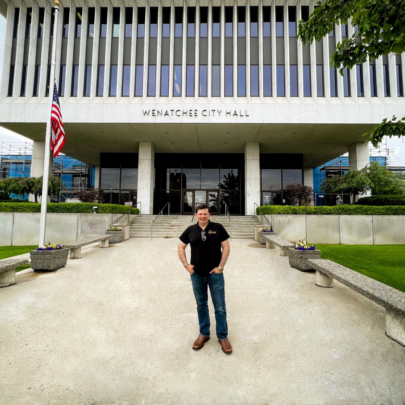 A person standing in front of a building Description automatically generated