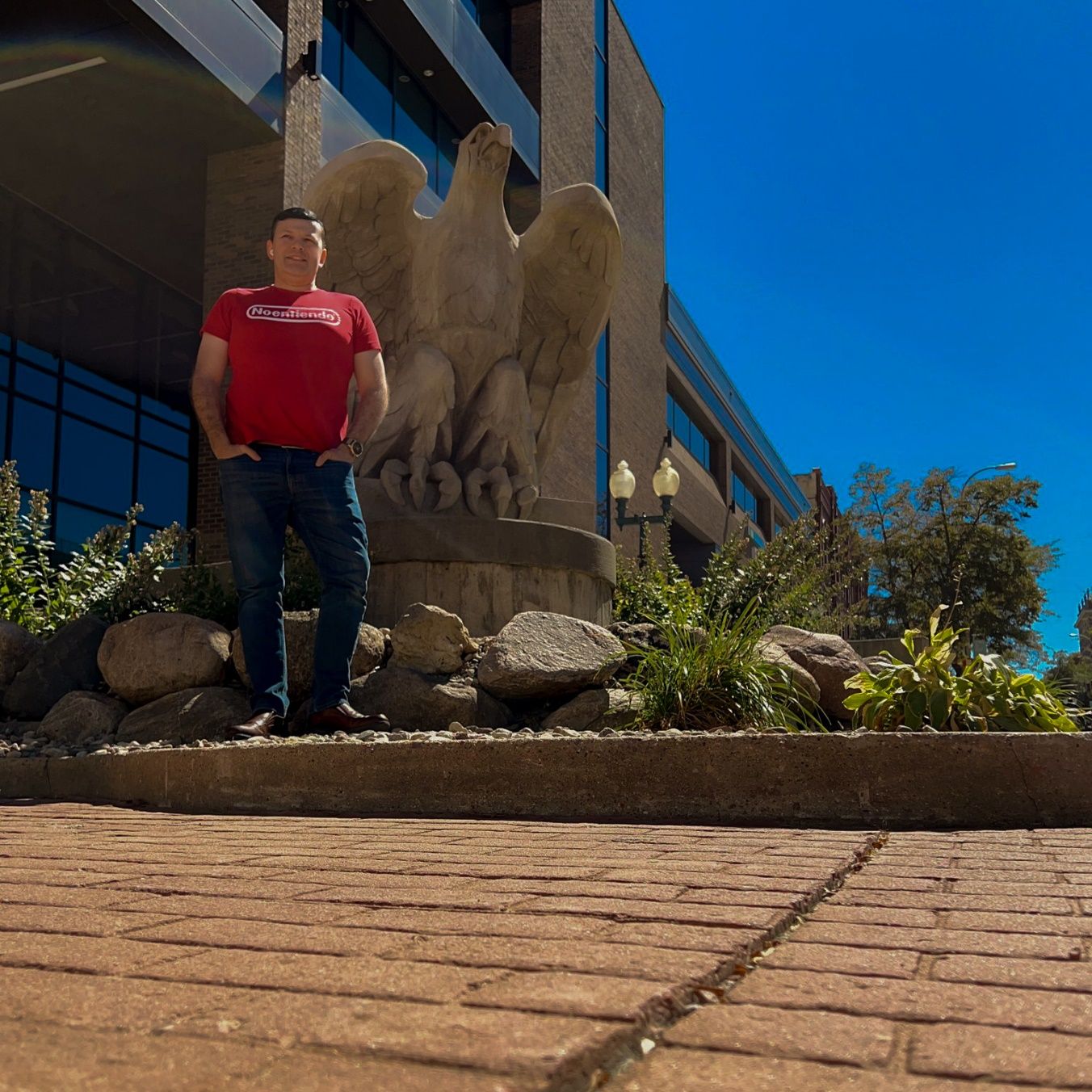 A person standing in front of a stone statue Description automatically generated