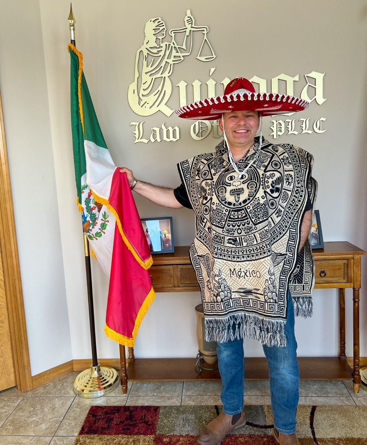 A person in a sombrero holding a flag Description automatically generated