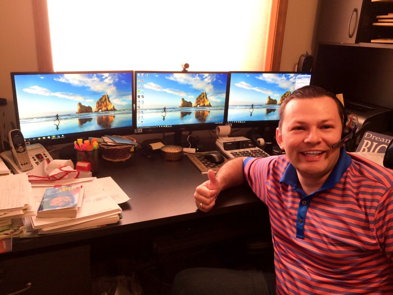 A person sitting at a desk with multiple monitors Description automatically generated