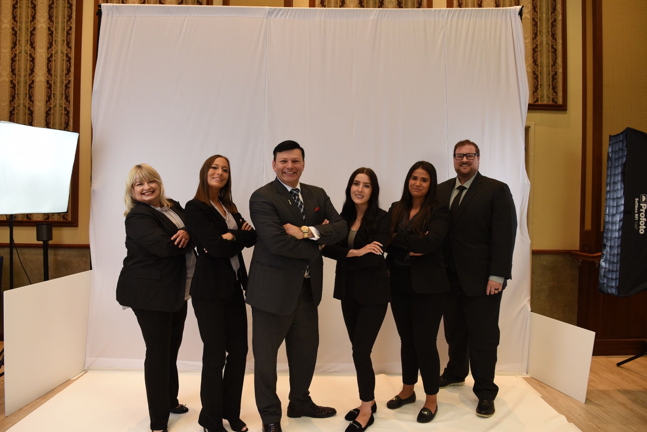 A group of people standing in front of a white backdrop Description automatically generated