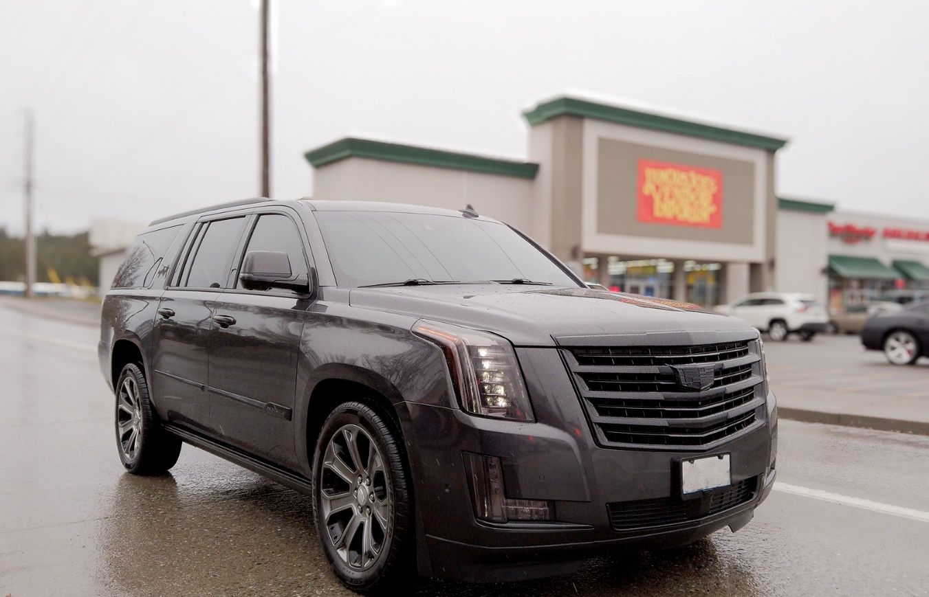A black suv parked in front of a store Description automatically generated
