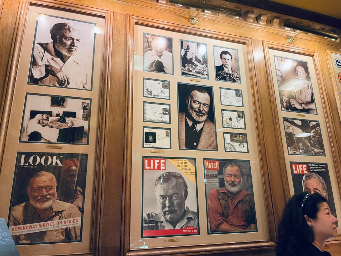 A person standing next to a wall with pictures of men AI-generated content may be incorrect.