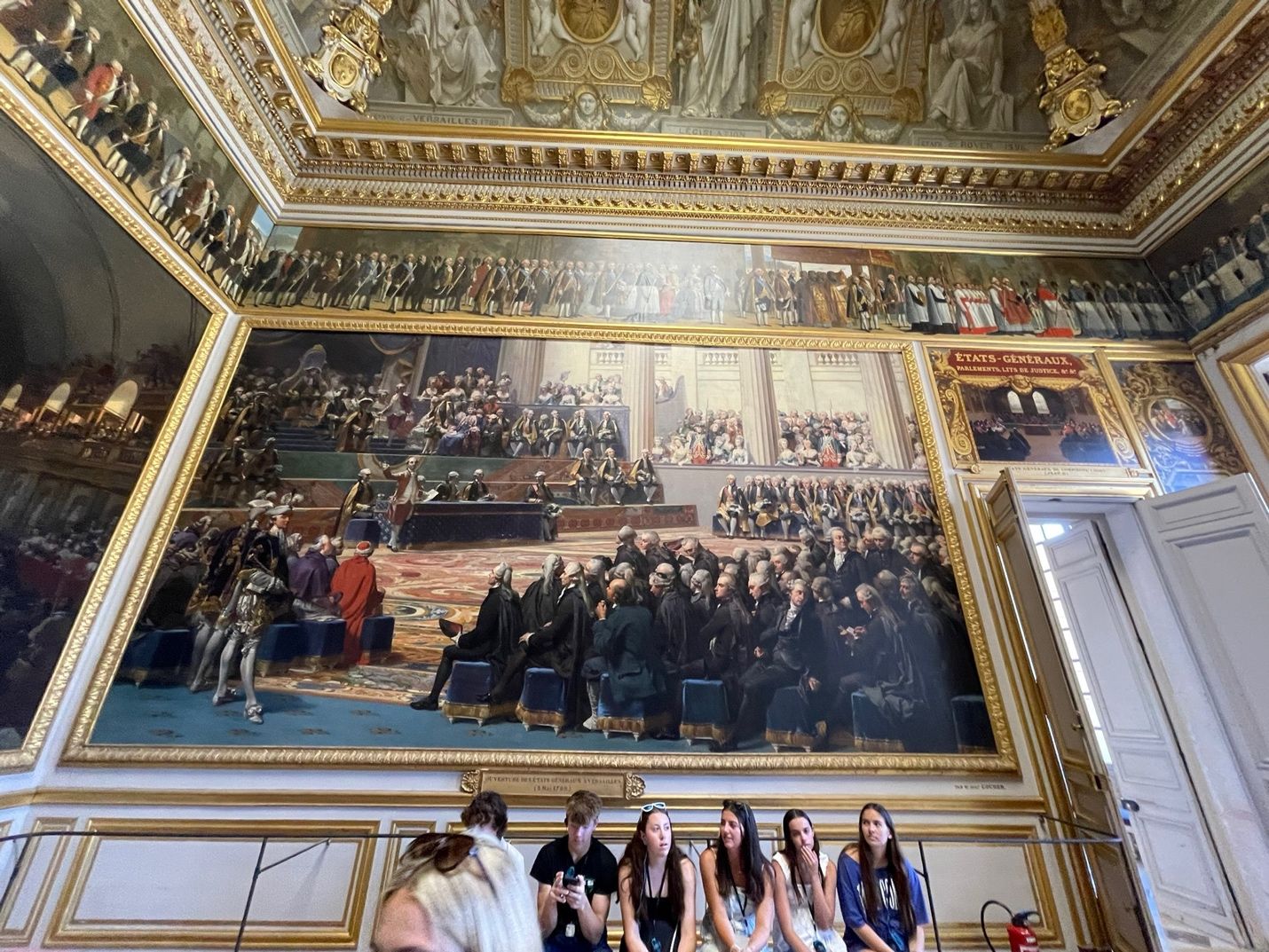 A group of people in a room with a large painting on the wall AI-generated content may be incorrect.