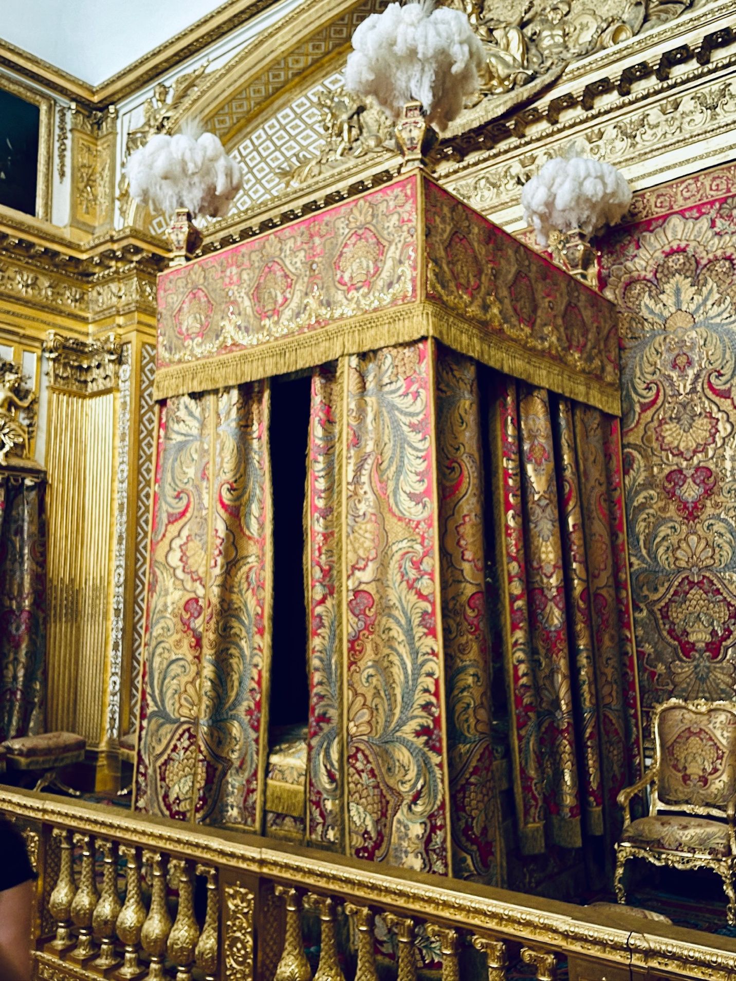 A gold and red canopy bed AI-generated content may be incorrect.