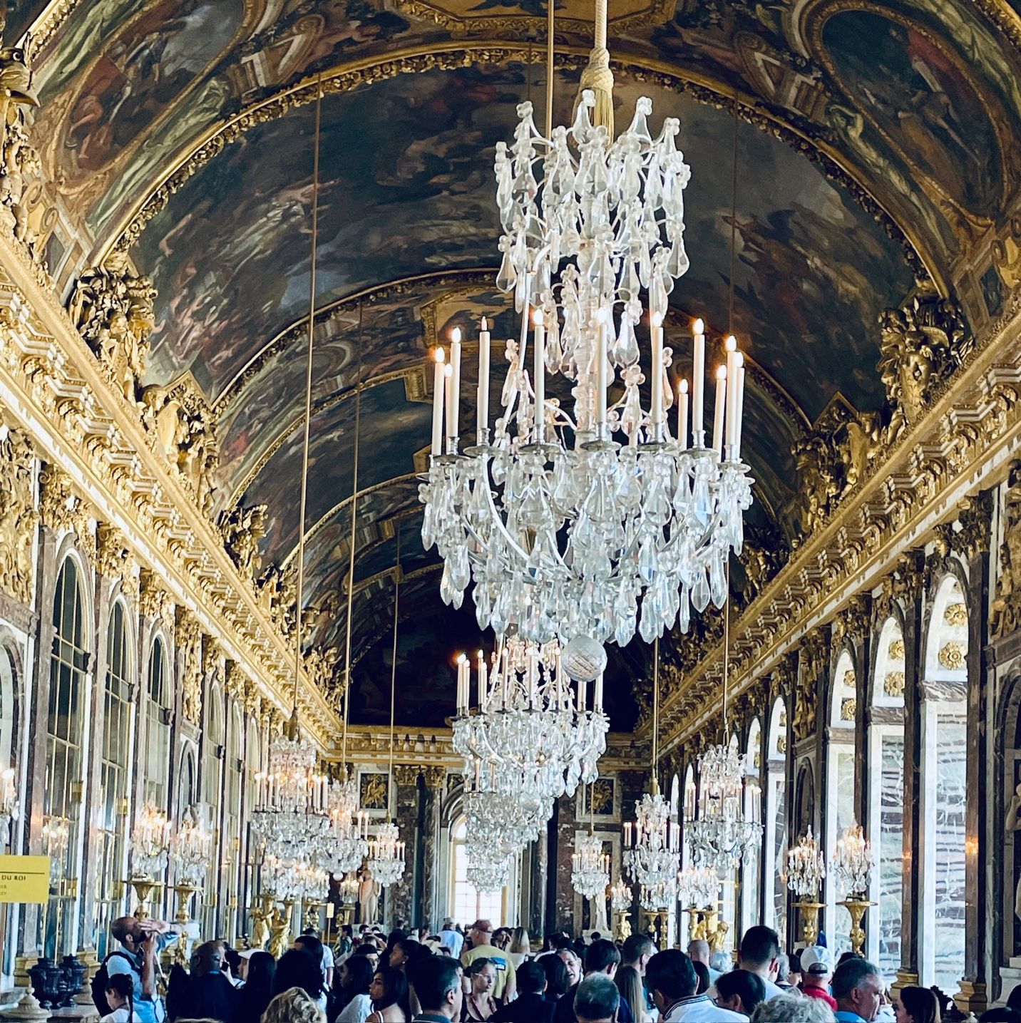 A group of people in a room with chandeliers AI-generated content may be incorrect.
