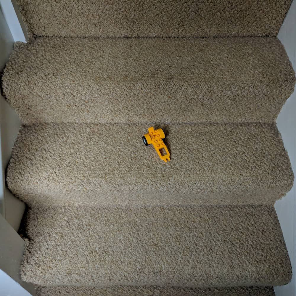 Stairs with a Lego trailer placed precariously and dangerously in the middle