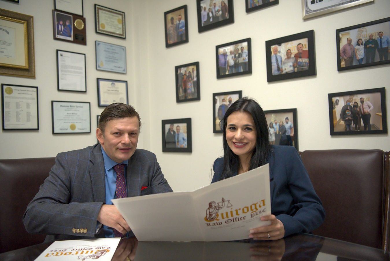 A person and person sitting at a table with a newspaper Description automatically generated