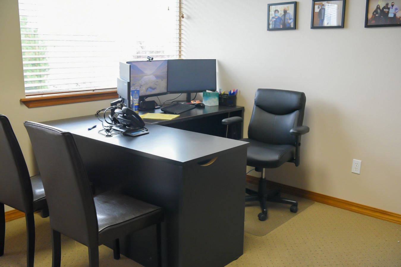 A desk and chair in an office Description automatically generated