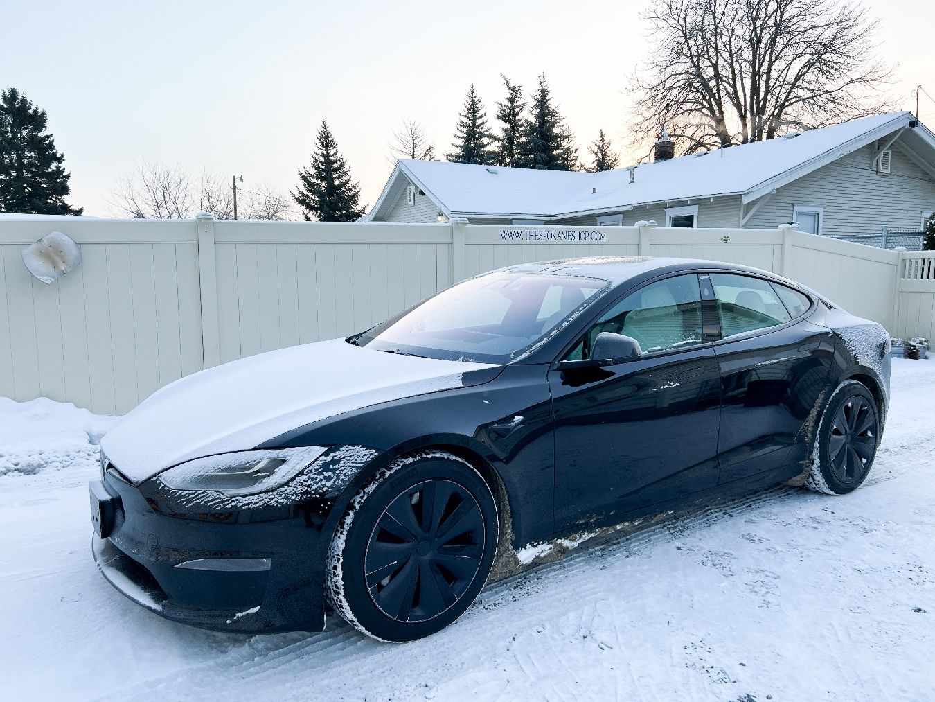 A black car parked in the snow Description automatically generated