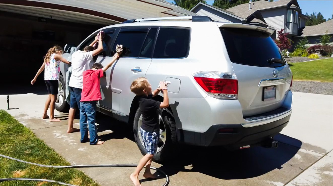 A group of people cleaning a car Description automatically generated