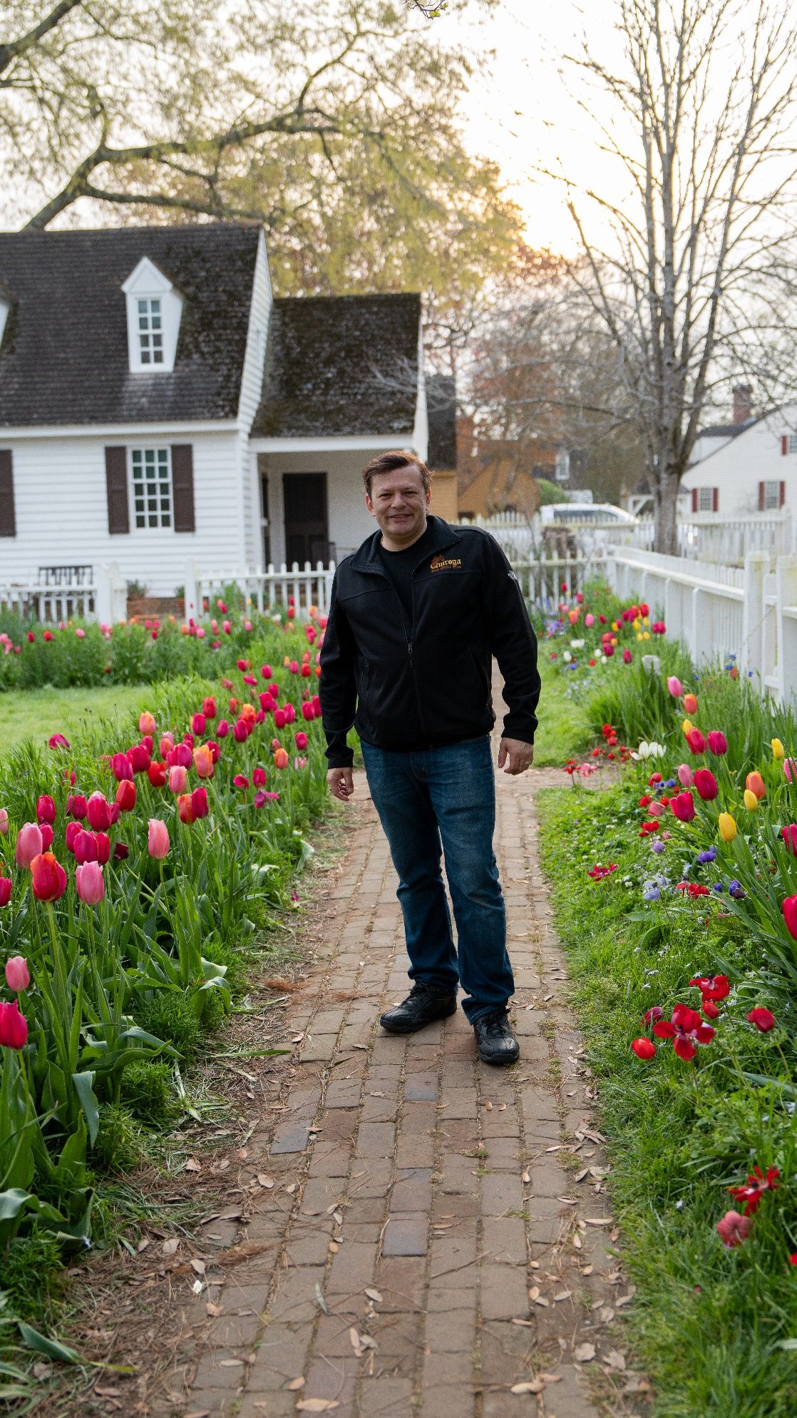 Un hombre con un jardín de flores Descripción generada automáticamente