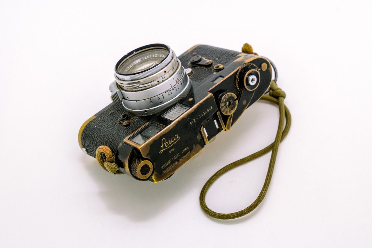 Sean Flynn’s Leica M2, with a “strap that was hand fashioned from a parachute cord and a hand grenade pin”.