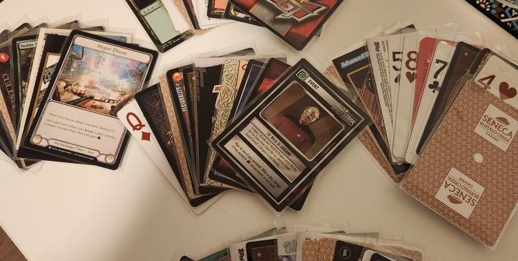 Several “hands” of cards: French-suited, TCGs, and others, spread out on a surface.