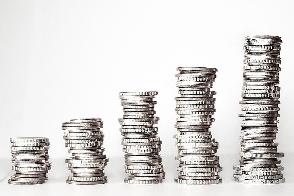 Five stacks of coins on a blank background.