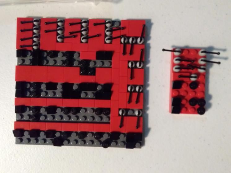 an 18x18 ish grid of Lego pieces. The surface is a mixture of smooth panels, small studs, and antenna pieces facing in different directions. A smaller “satellite” board is similarly configured.