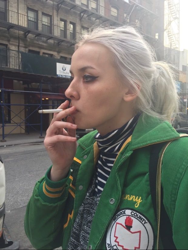 A person smoking a cigarette Description automatically generated with medium confidence