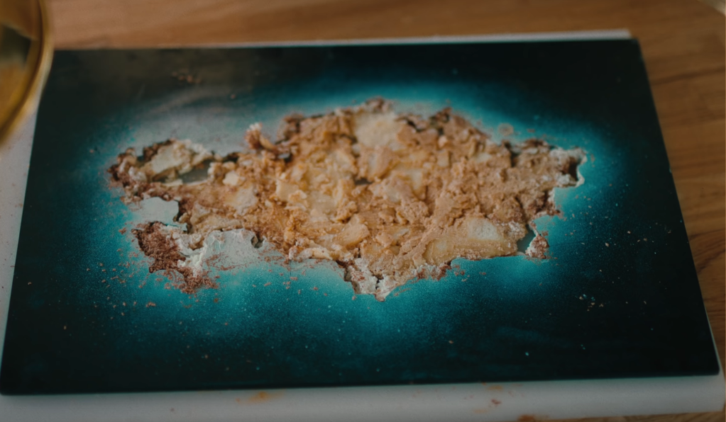 Image of a plate with crumbs lying in the middle of a blue template with the shape of Kazakhstan cut out of it