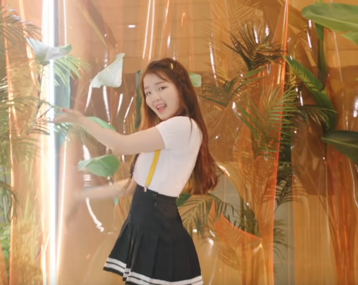 picture of Seunghee in a sailor suit and suspenders, dancing, her body turned to the right and her arms out in front of her