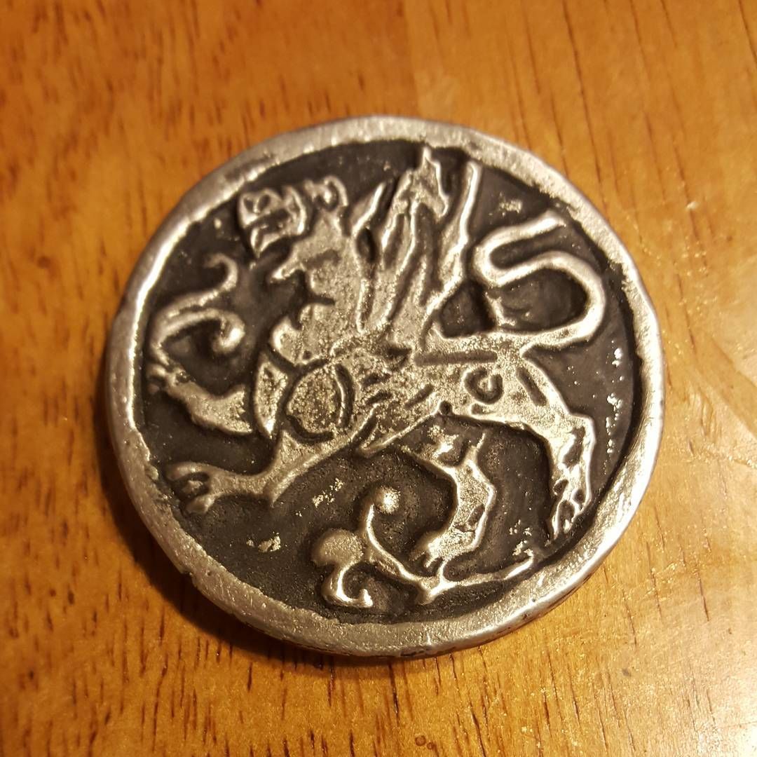 Pew… pew… pewter!! I’ve been wanting to make some things out of more durable materials than resin in the past few months and thinks to a great video from +Punished Props​ on using pewter to cast 3D models I decided to jump in and do a test! (Thanks Bill and Brit!) Link: http://punishedprops.com/2015/12/02/prop-3d-metal-amulet/So now I’m minting my own Silver Griffin coins! Casting pewter was not super difficult and the end results are petty cool, I mean these coins have some heft to them! So it all starts with Mold Max 60 from Smooth-On which is a dark red, heat resistant silicone that can take about 550 degrees which happens to be higher than the melting point of pewter and Tin as well.The cool part is the whole process is pretty much the same as casting resin with the exception of the molten metal which requires special equipment including flame resistant gloves and safety glasses (Just use them, don’t want mistakes with molten metals!) There are a few notable differences, first big one is that MoldMax 60 takes 24 hours to cure so be prepared to wait, it’s hard but it is what it is huh? Second thing, I discovered that per liquid ounce, there is something more costly than resin, yes pewter! Lol So be prepared if your looking to make something sizable!Other interesting things I learned was that when you ladle out the metal, it sets pretty fast so you have to be ready to pour it into the mold asap, you have a second or two before the surface of the molten metal starts to cool and solidify, despite that I was able to get a good cast on my second try so it just takes a little practice. Finally I discovered that the mold doesn’t seem to hold up very well, not that I can blame it, but I was a little disappointed to have some of the details of the mold tear out in the casting on the 6th pull. I’ll be researching what can be done to prevent that, hopefully there is a trick to get a little more longevity out of my mold!I’ll be casting more pewter for sure though and maybe offer up casting services to other artists if anyone becomes interested! ‪‎somakeitmonday‬﻿ propmaking
