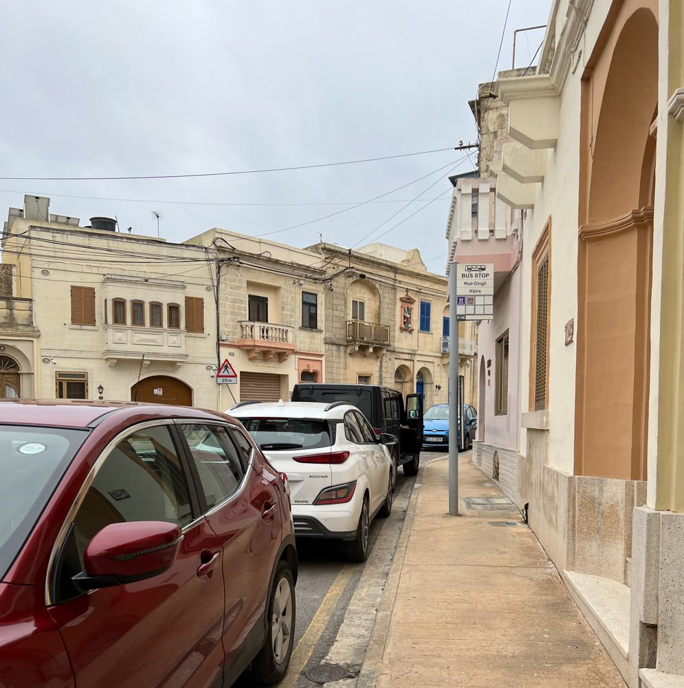 A bus stop blocked by parked cars