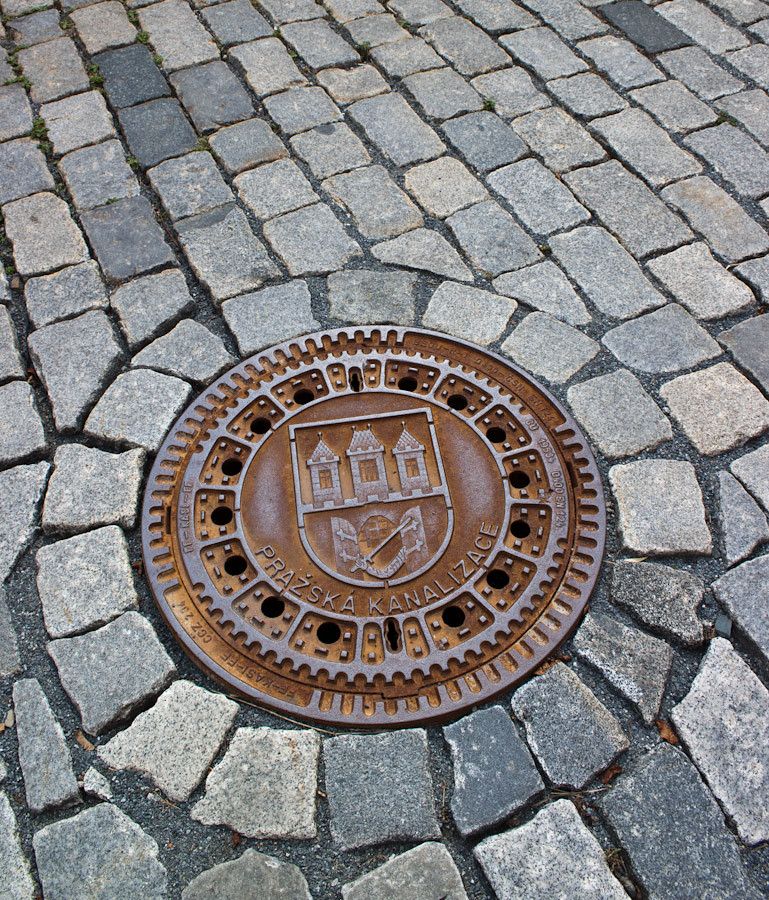 Detailed manhole cover and cobbled stones