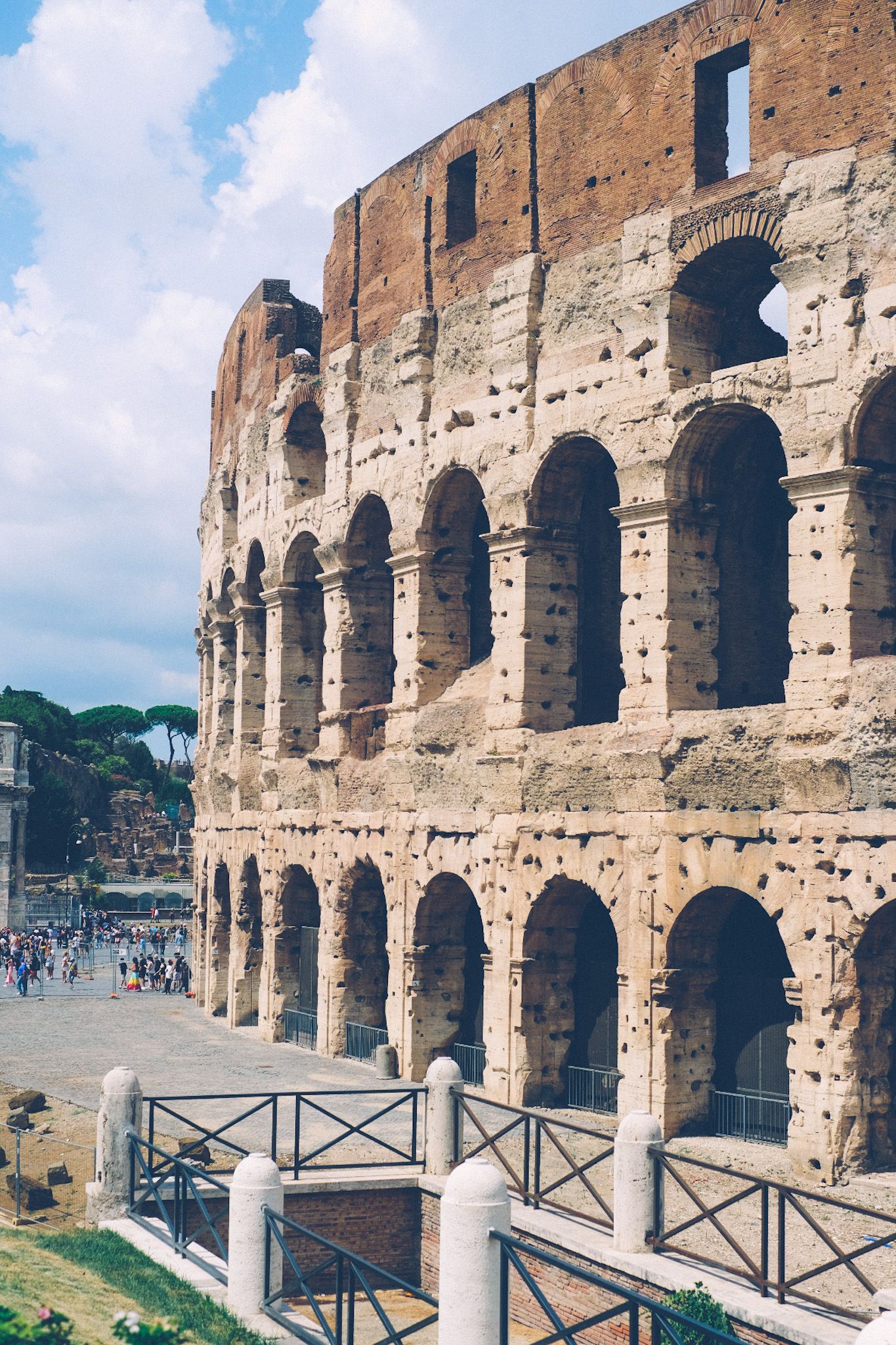 A side view of the Roman colosseum mid-day, in the sunlight.